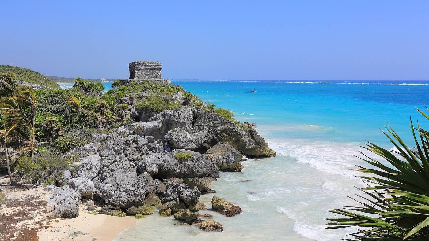 A Maya cliff-top temple at Tulum overlooking a brilliant turquoise Caribbean sea.