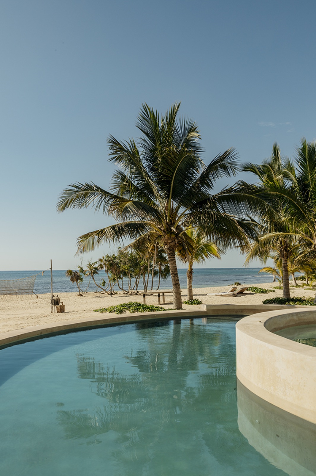 Beachfront pool and palms on Corasol's private white-sand beach (verified, portrait)