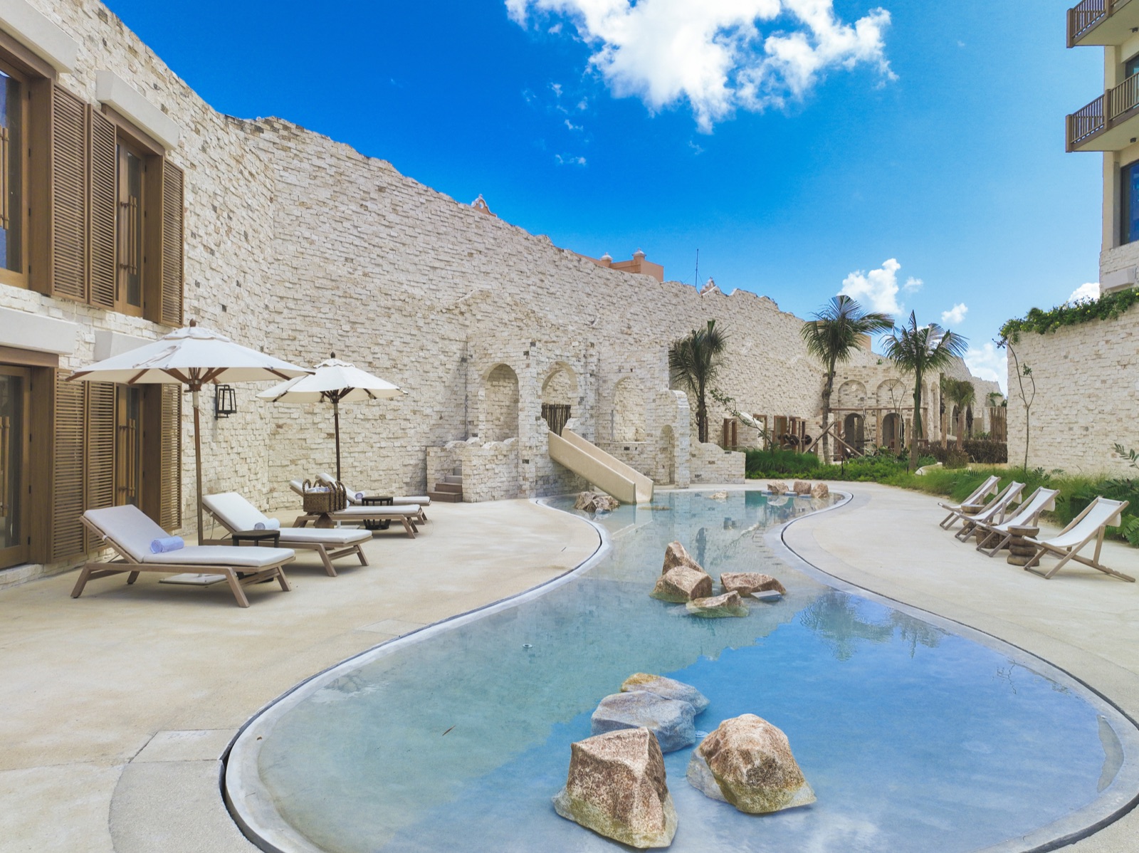 Costa Beach Club stone courtyard with lagoon pool, slide and loungers (verified, 5280x3956)
